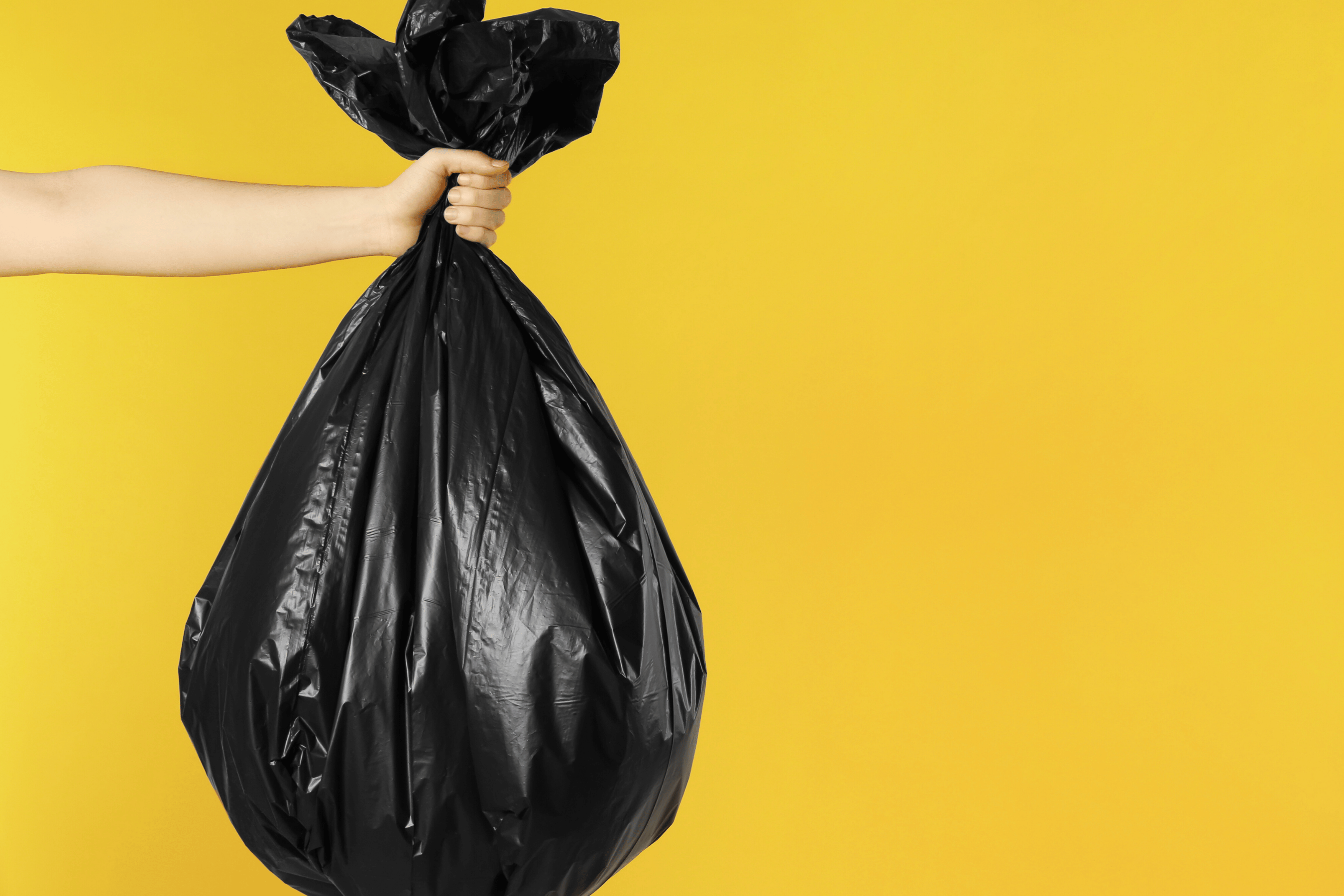 Woman holds a full garbage bag