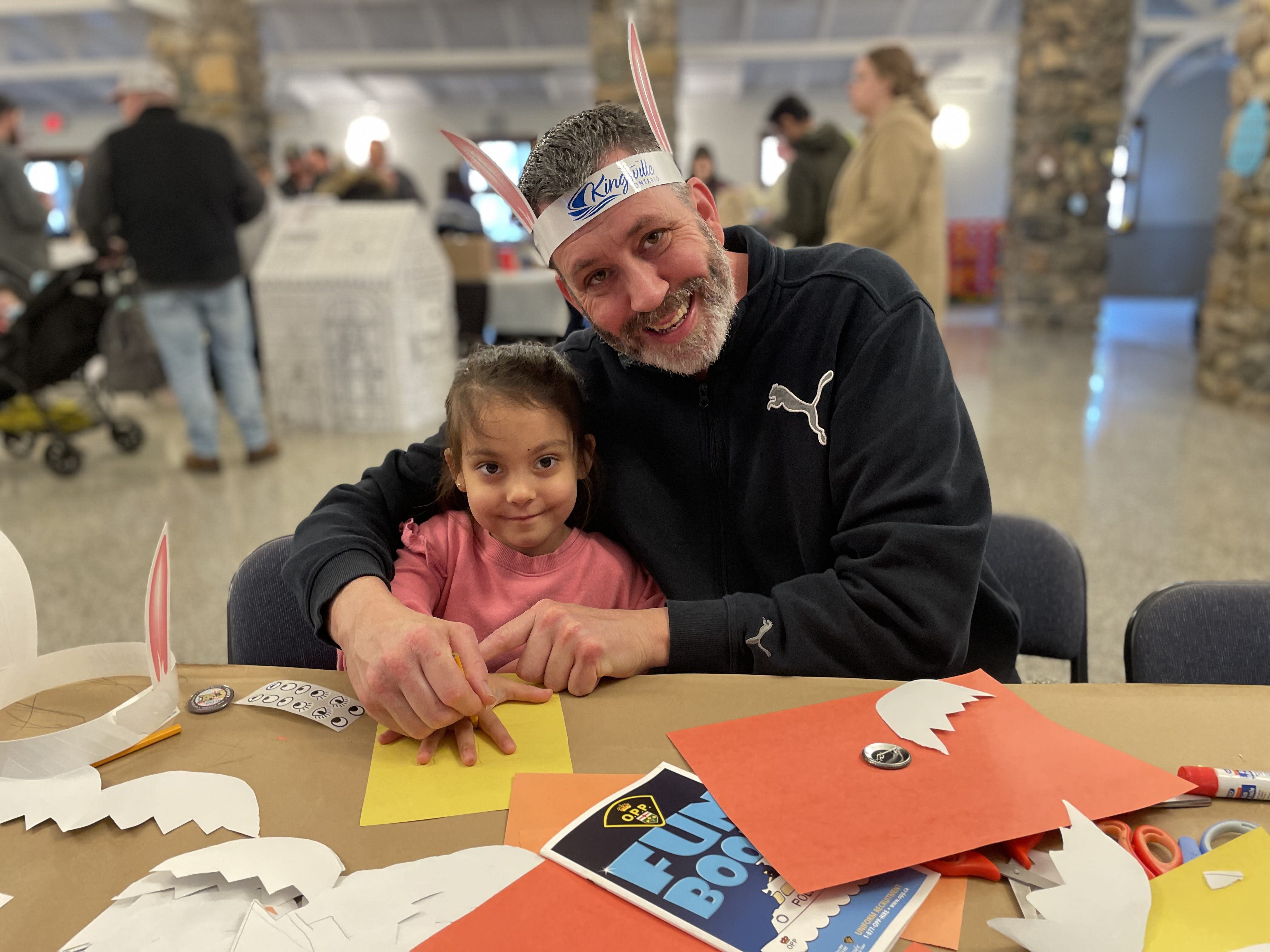 A dad and daughter do easter crafts at at Town Easter Egg Hunt