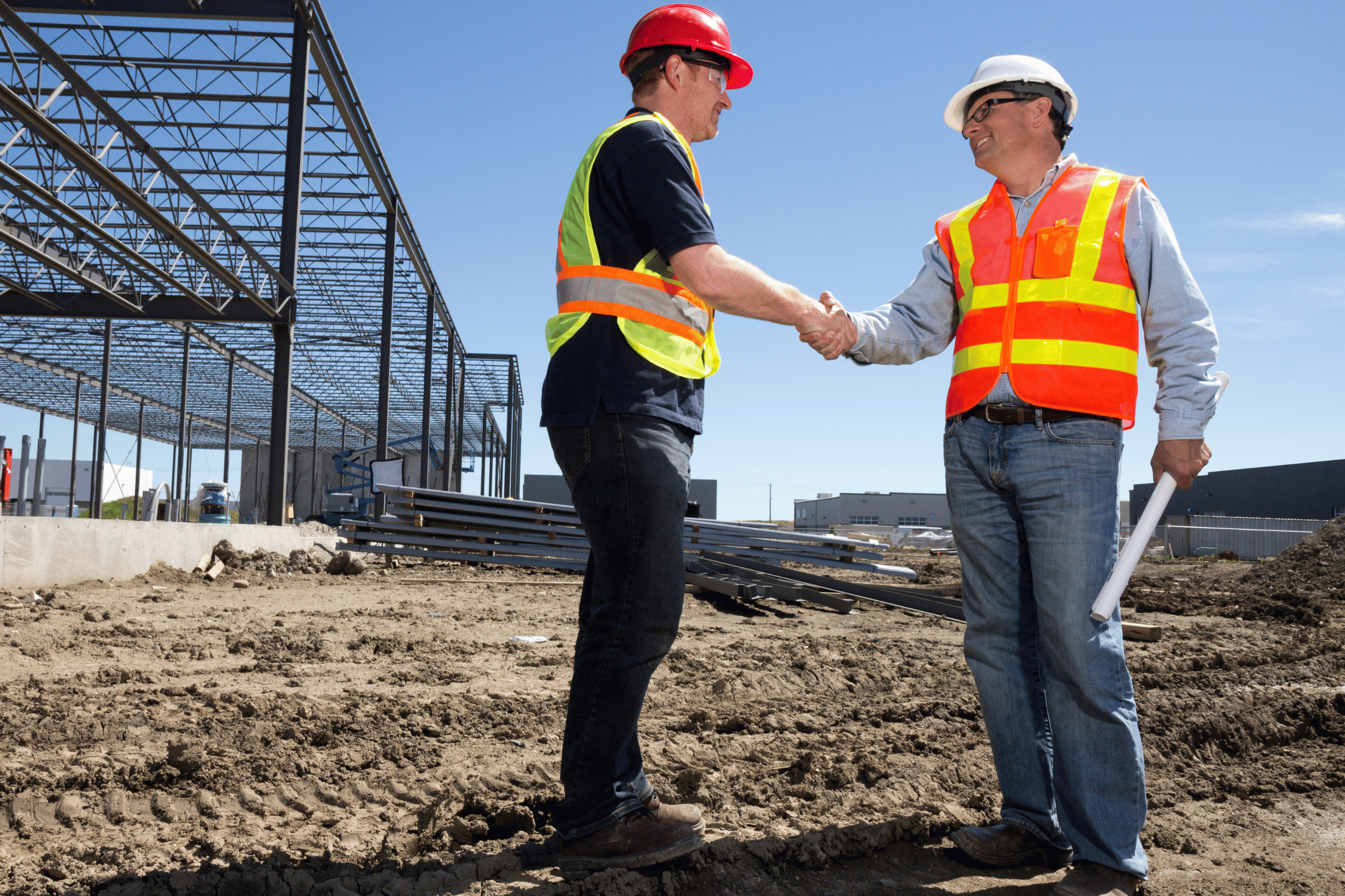 Construction workers shake hands on a job site