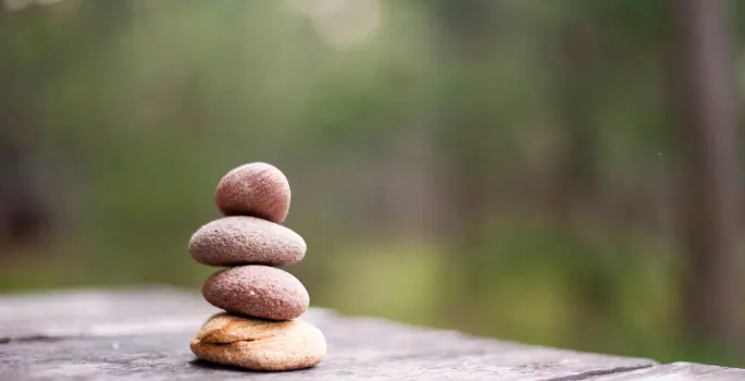 Small round rocks are stacked into a tower