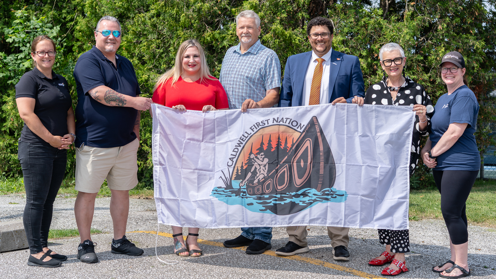 Members of Town Council, Town of Essex Council, County of Essex Council, and Caldwell First Nation holding the Caldwell First Nation Flag