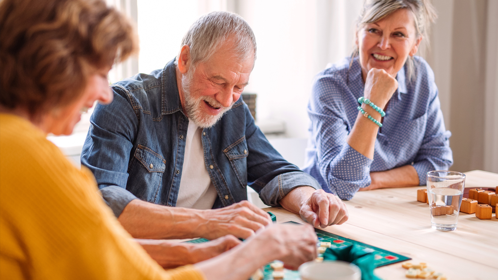 A group of older adults playing a board game at a table