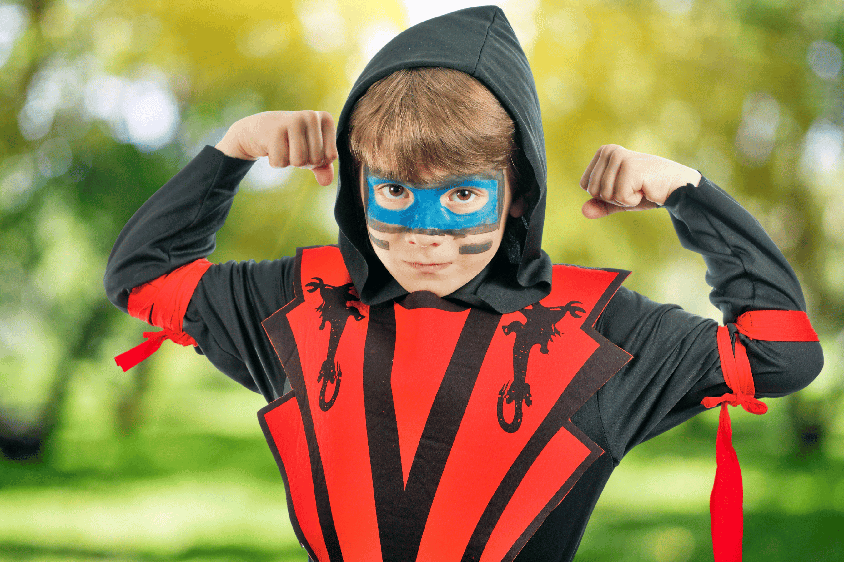Young boy flexes in ninja costume
