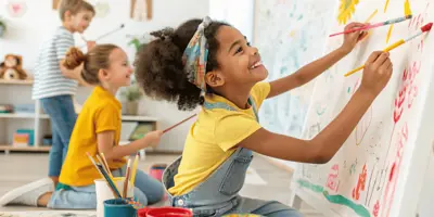 Three youths happily paints on canvases