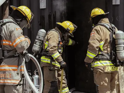 Group of firefighters prepare to enter a doorway