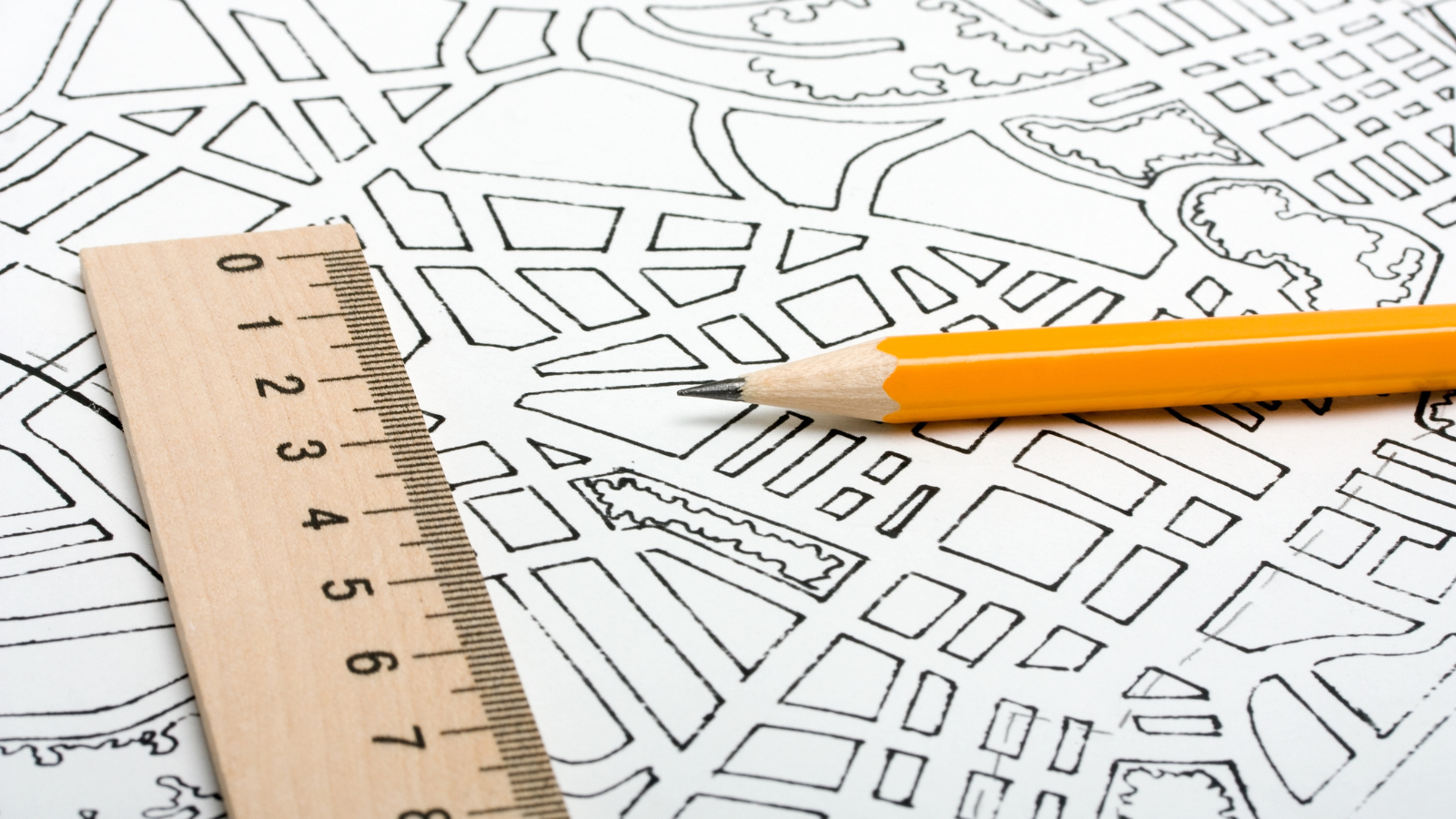 A blueprint, pencil and ruler sit on a table