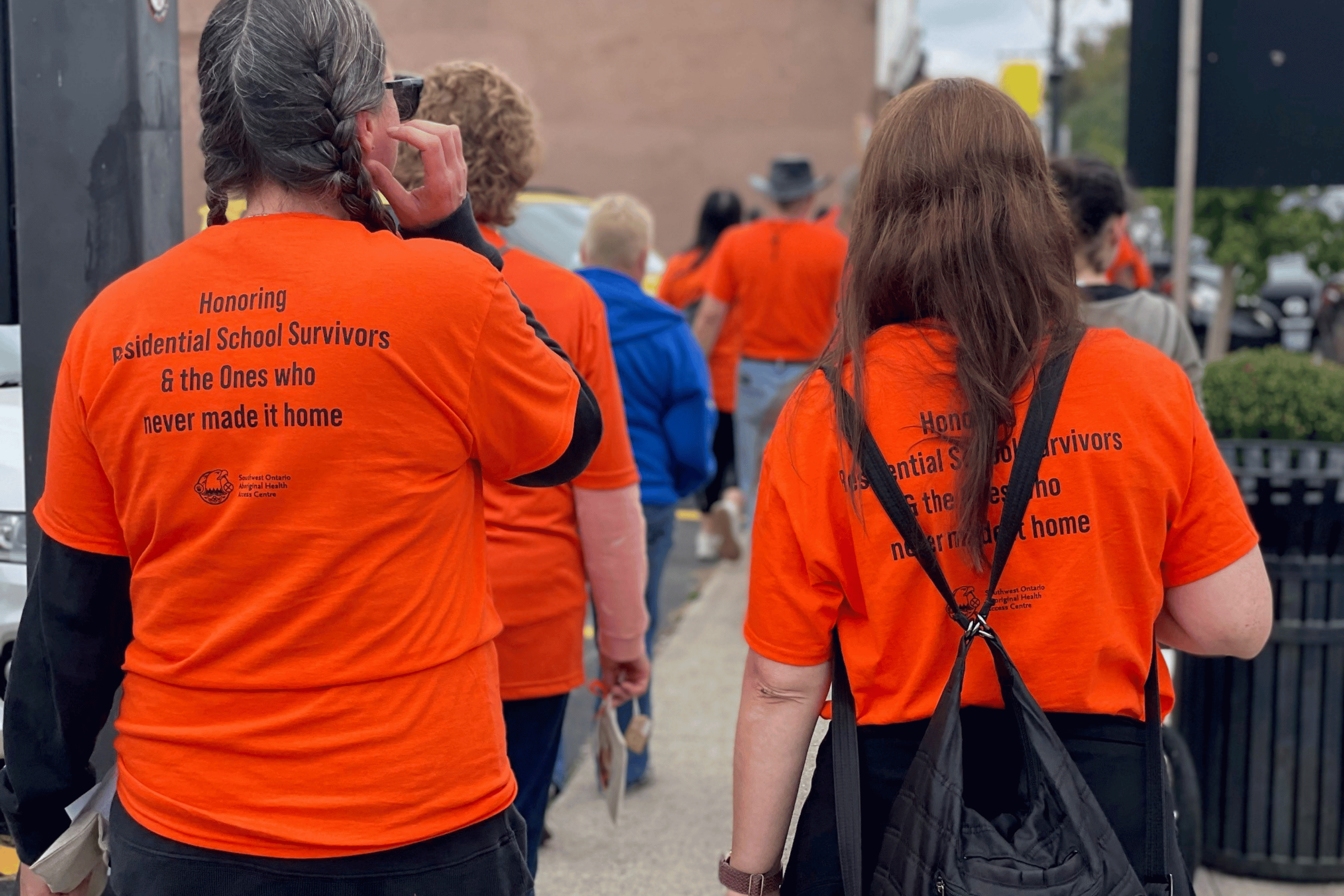 People in orange shirts walk to honour residential school victims and survivors