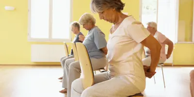 Women concentrate on stretching while in a seated position