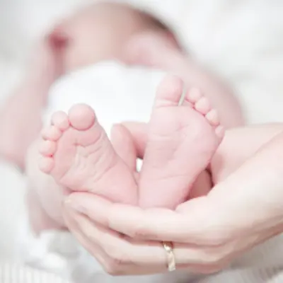 New mom holds newborn's feet