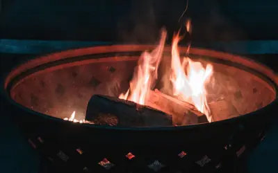 A fire and firewood in a burn pit.