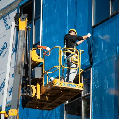 Construction workers make building facade improvements
