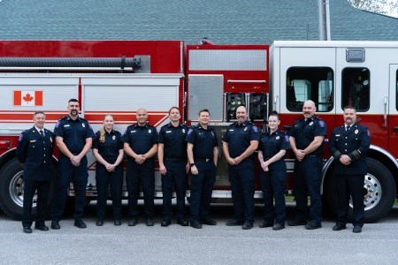 Class of 2024 Fire recruits stand with Fire Department personnel in front of fire truck