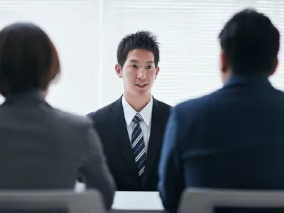 Man in tie addresses interview panel