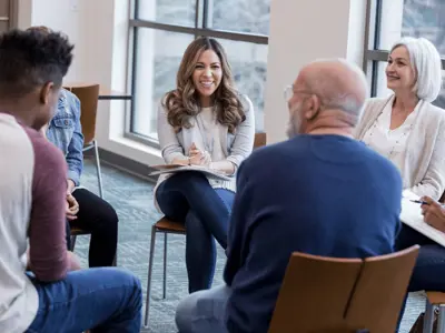 Group of happy citizens sit in a circle exchanging ideas
