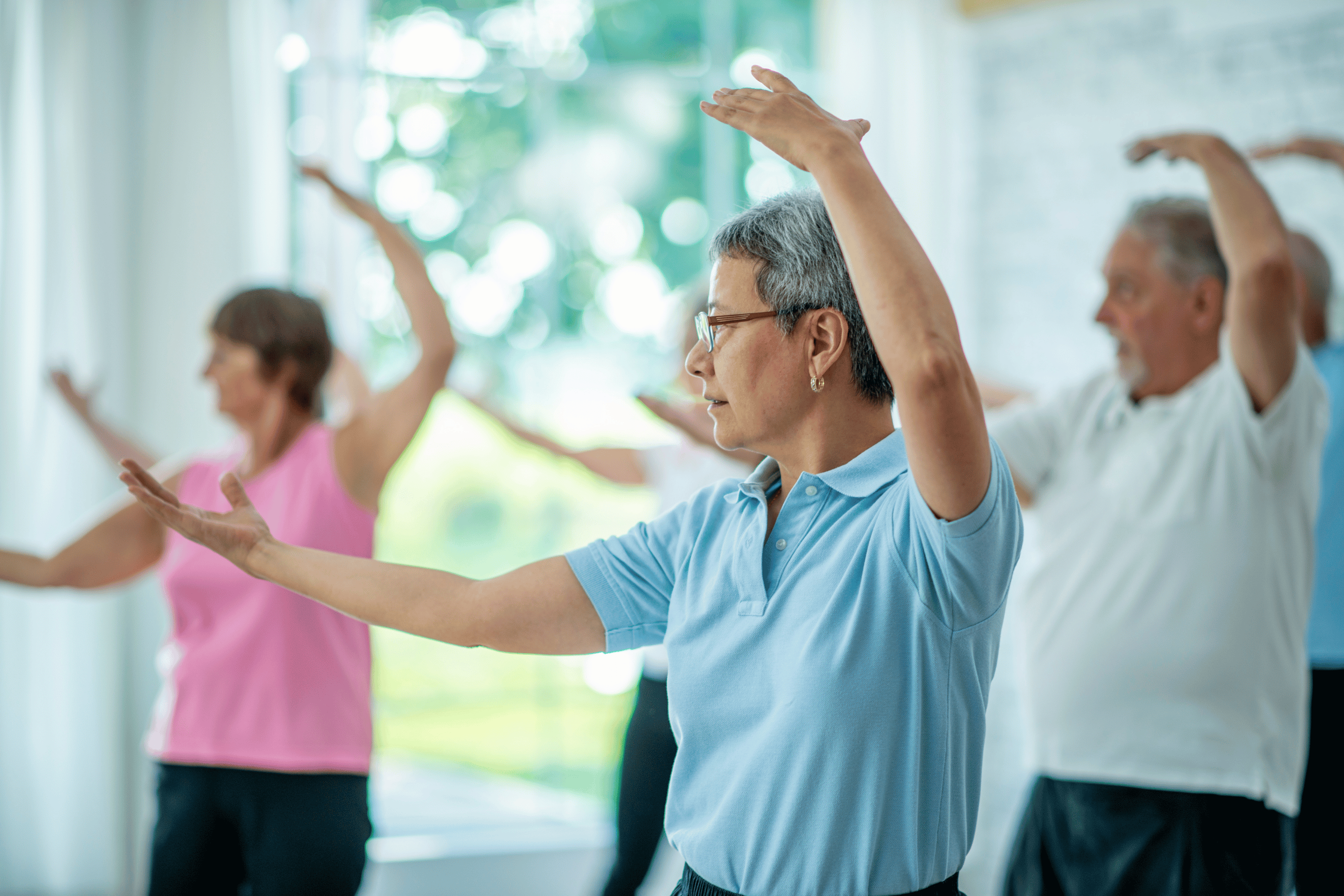 A group of older adult practice tai chi poses