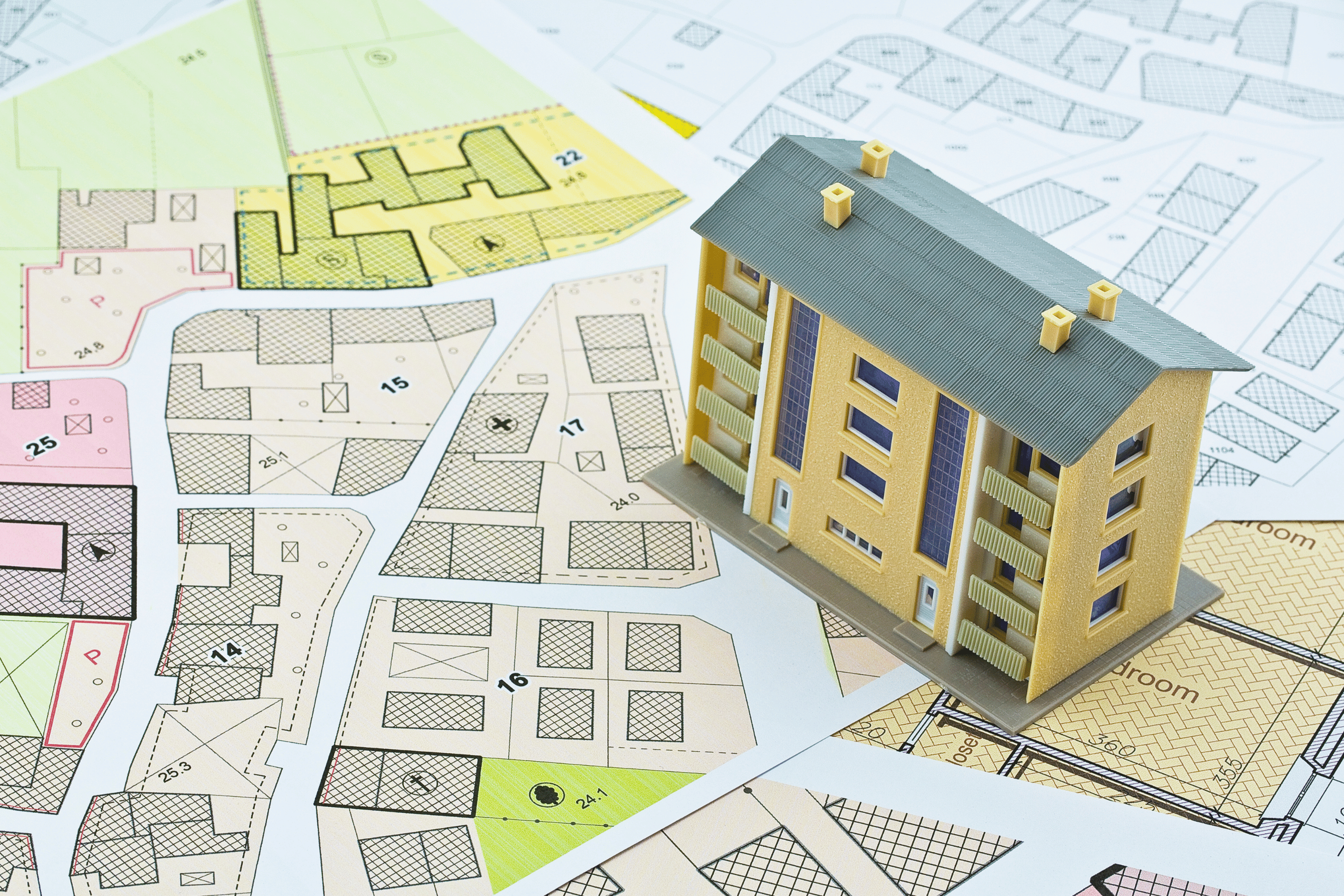 Model home rests on a map with parcels highlighted